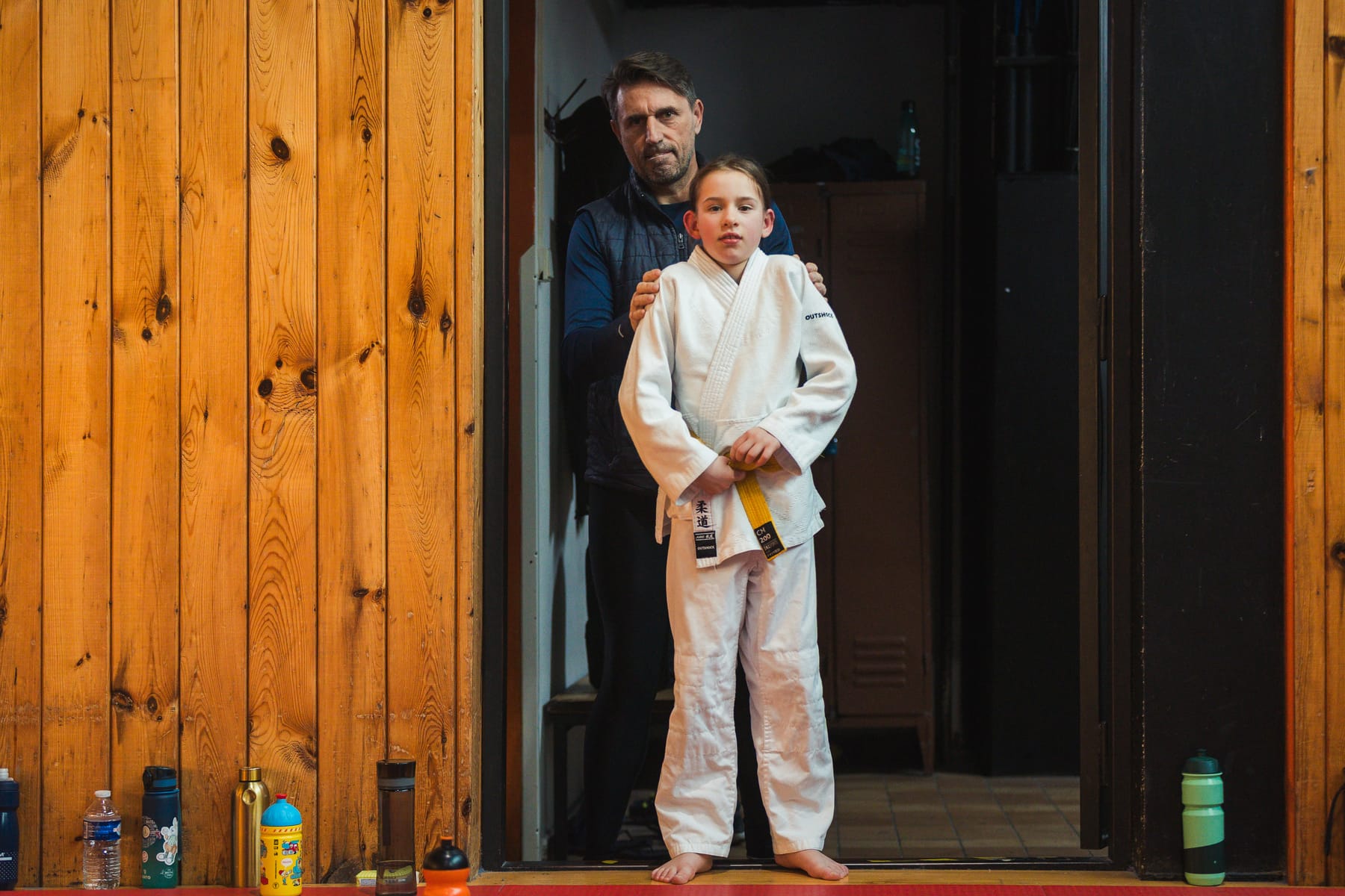 Děti a trenéři při společné práci na tatami